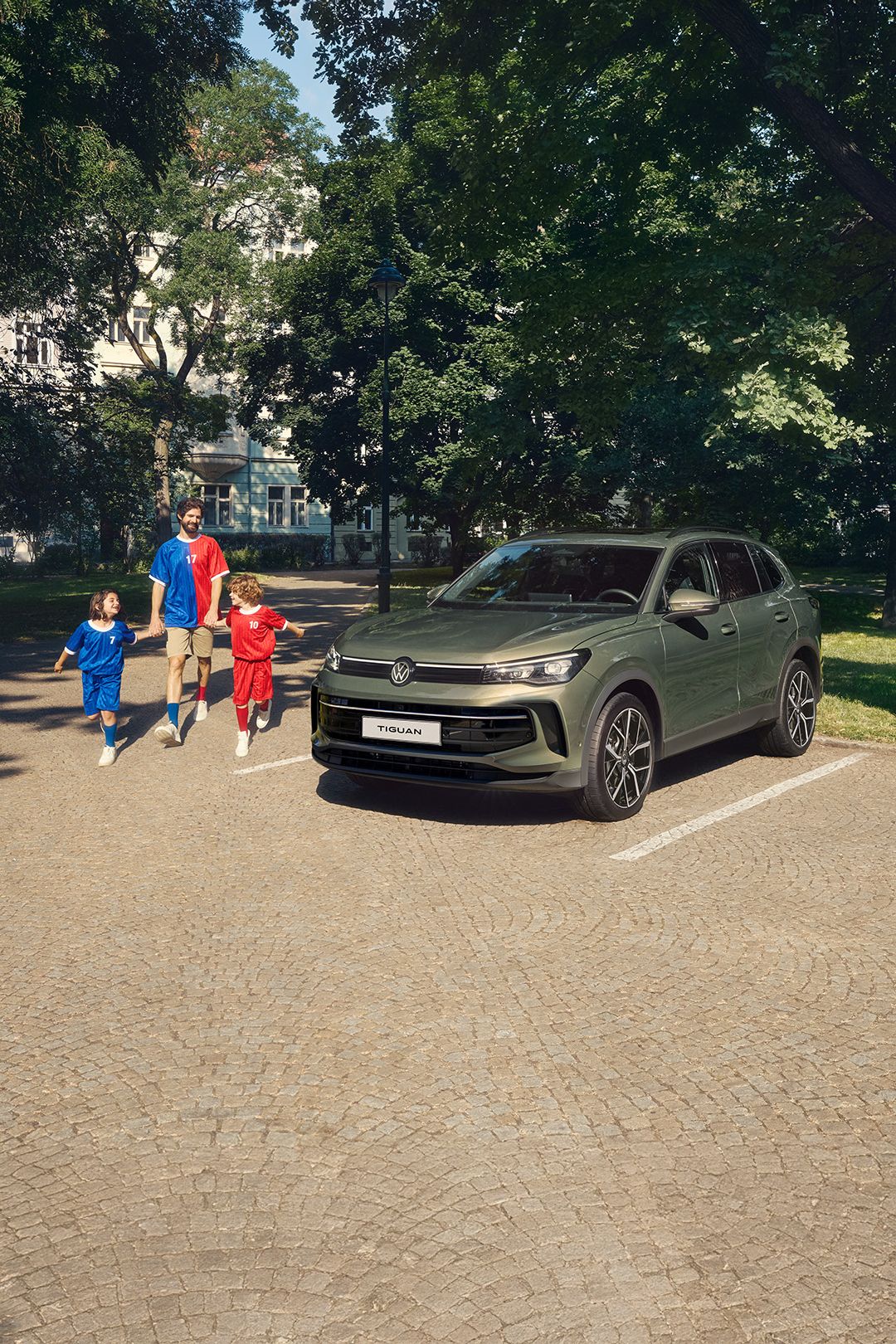 A family of three walking merrily by their trusty Tiguan