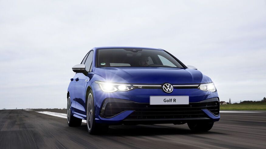 A man is driving a Volkswagen blue Golf R on the road with turning on the front LED headlight in a cloudy weather