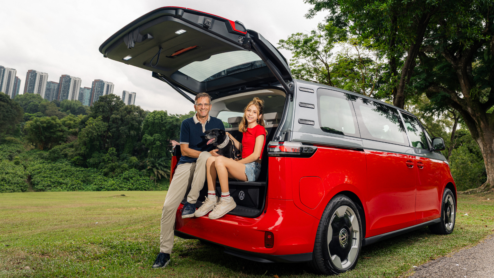Father and daughter duo happily sitting at the rear of their Cherry Red ID. Buzz