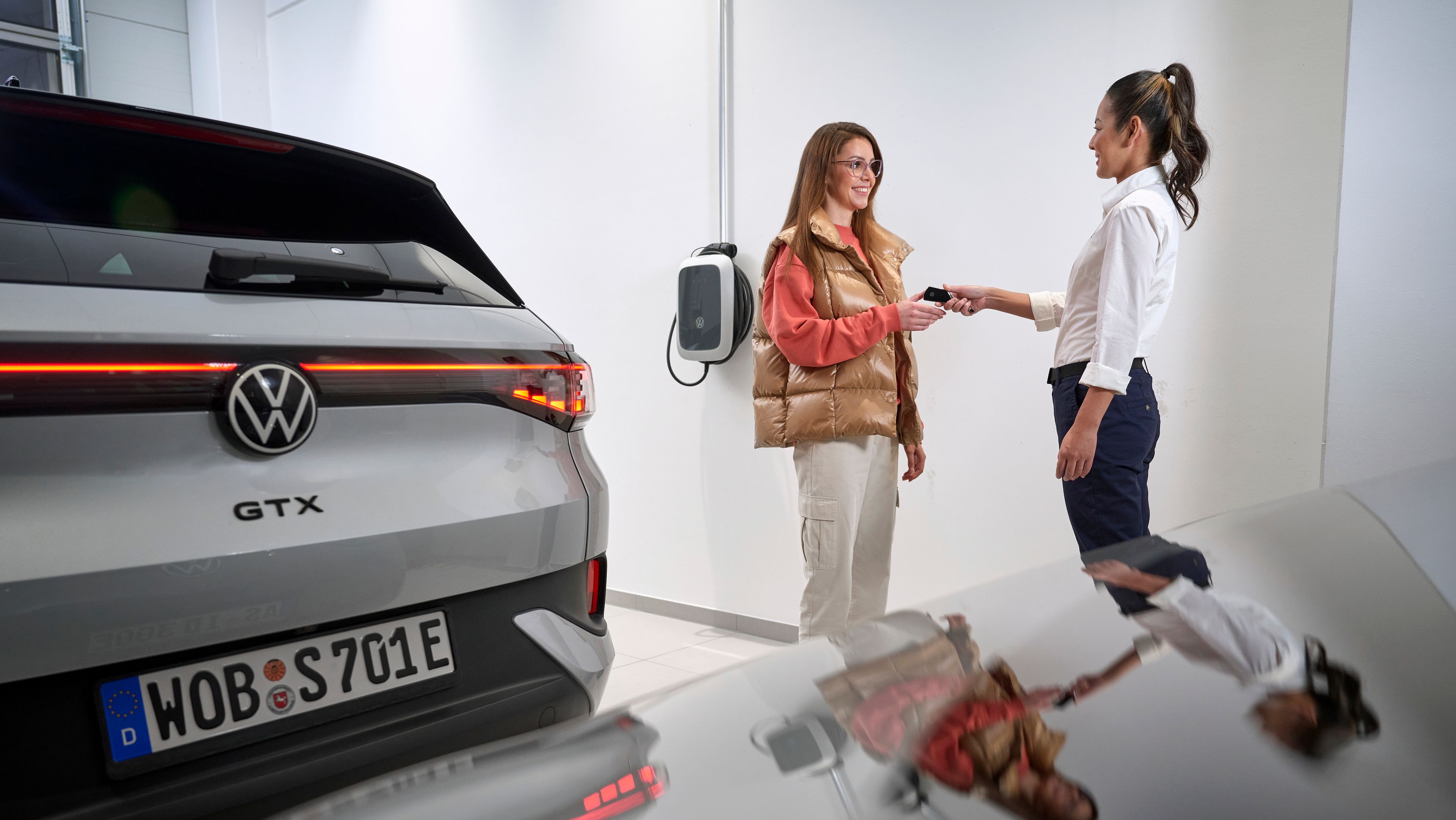 A Volkswagen service advisor handing the keys of an ID.4 GTX to a customer