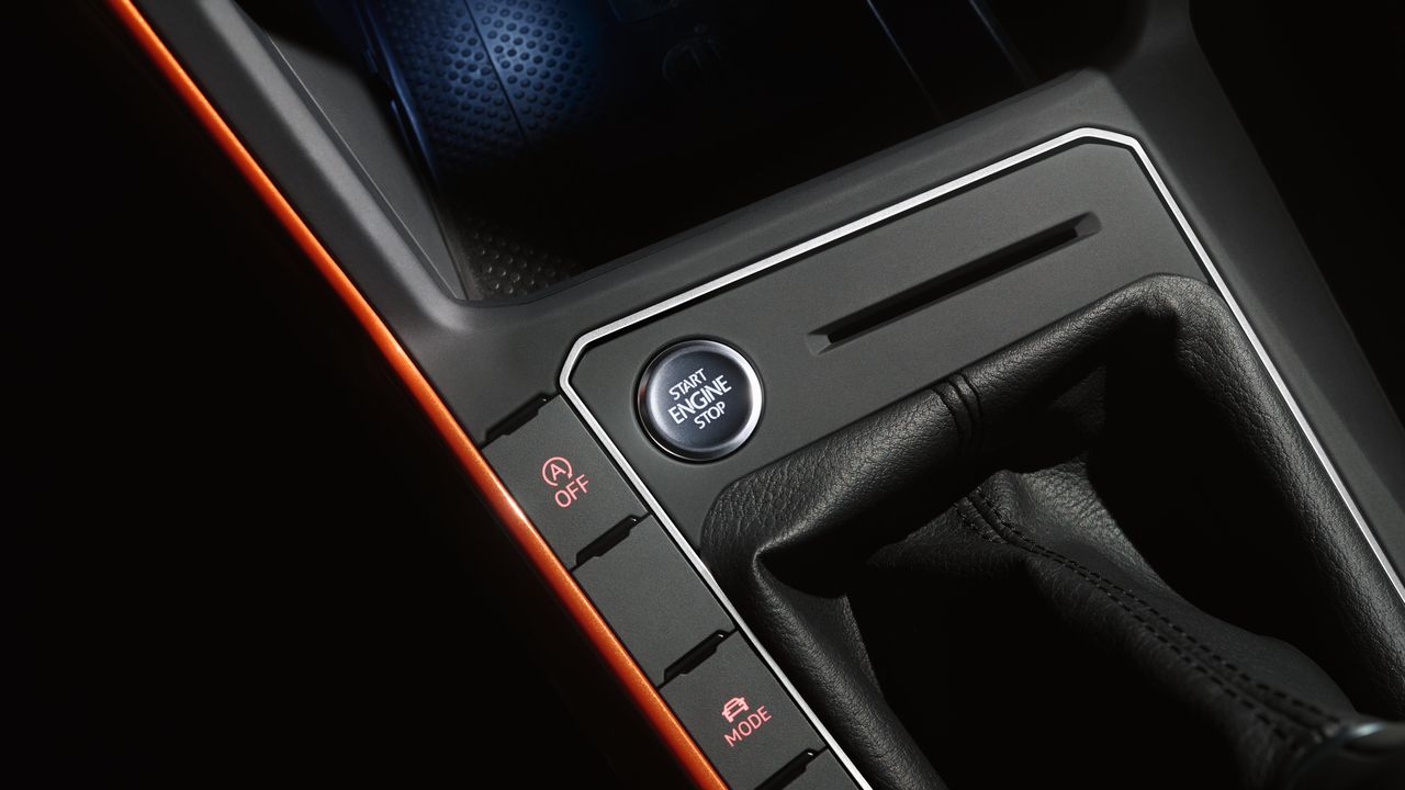 A close-up view of the Stop-Start button located in front of the gearbox of a Volkswagen vehicle.