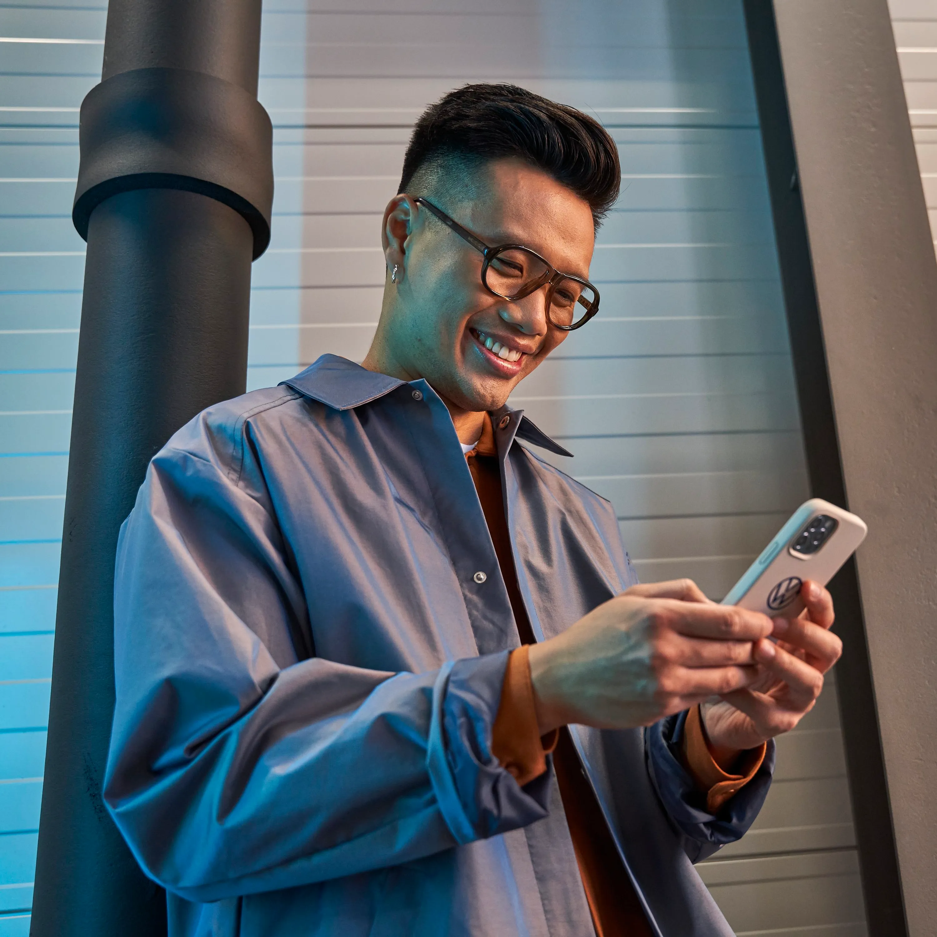 A well-dressed man using his smartphone to visit the Volkswagen eShowrrom online.