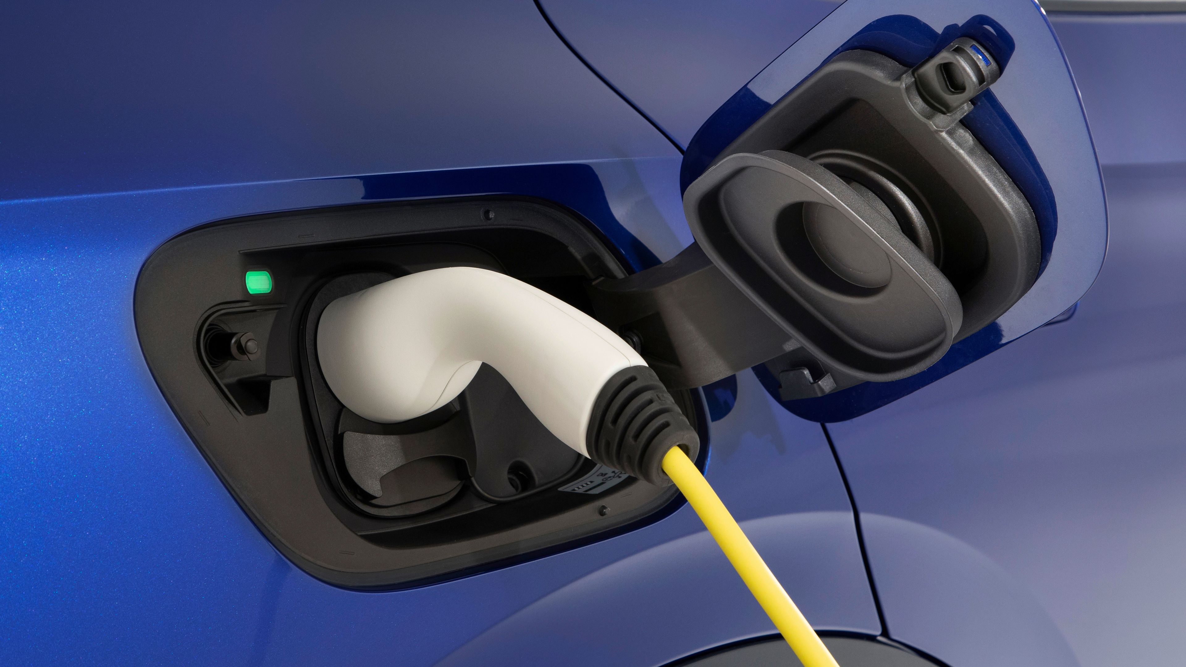 The charging port of the Volkswagen ID.4, with a green light indicating that its fully charged.