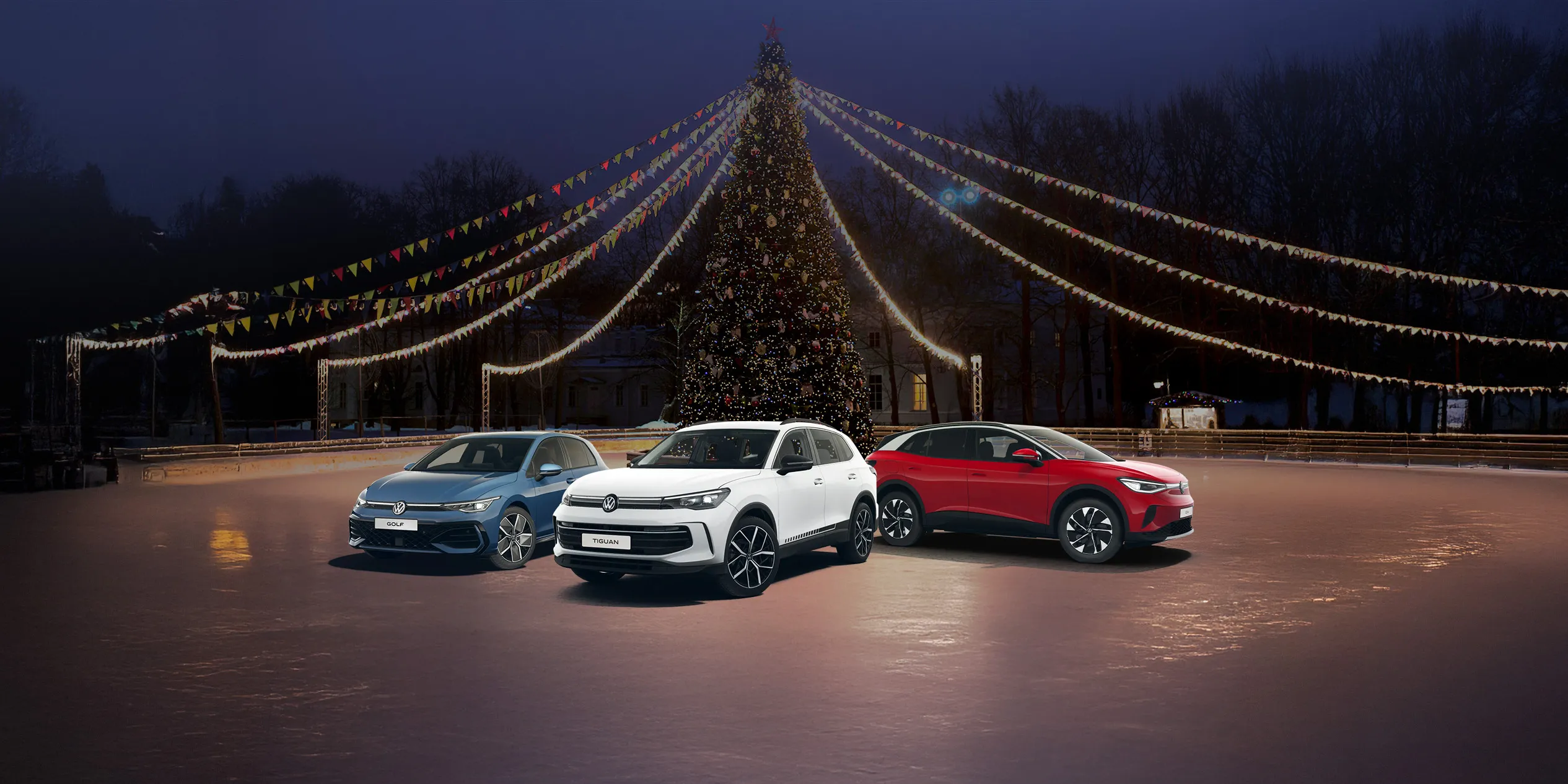 A blue Golf, a white Tiguan and a red ID.4 parked in front of a grand Christmas tree