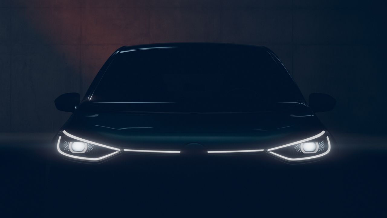 A Volkswagen vehicle with its LED headlights turned on in a dark and enclosed space.