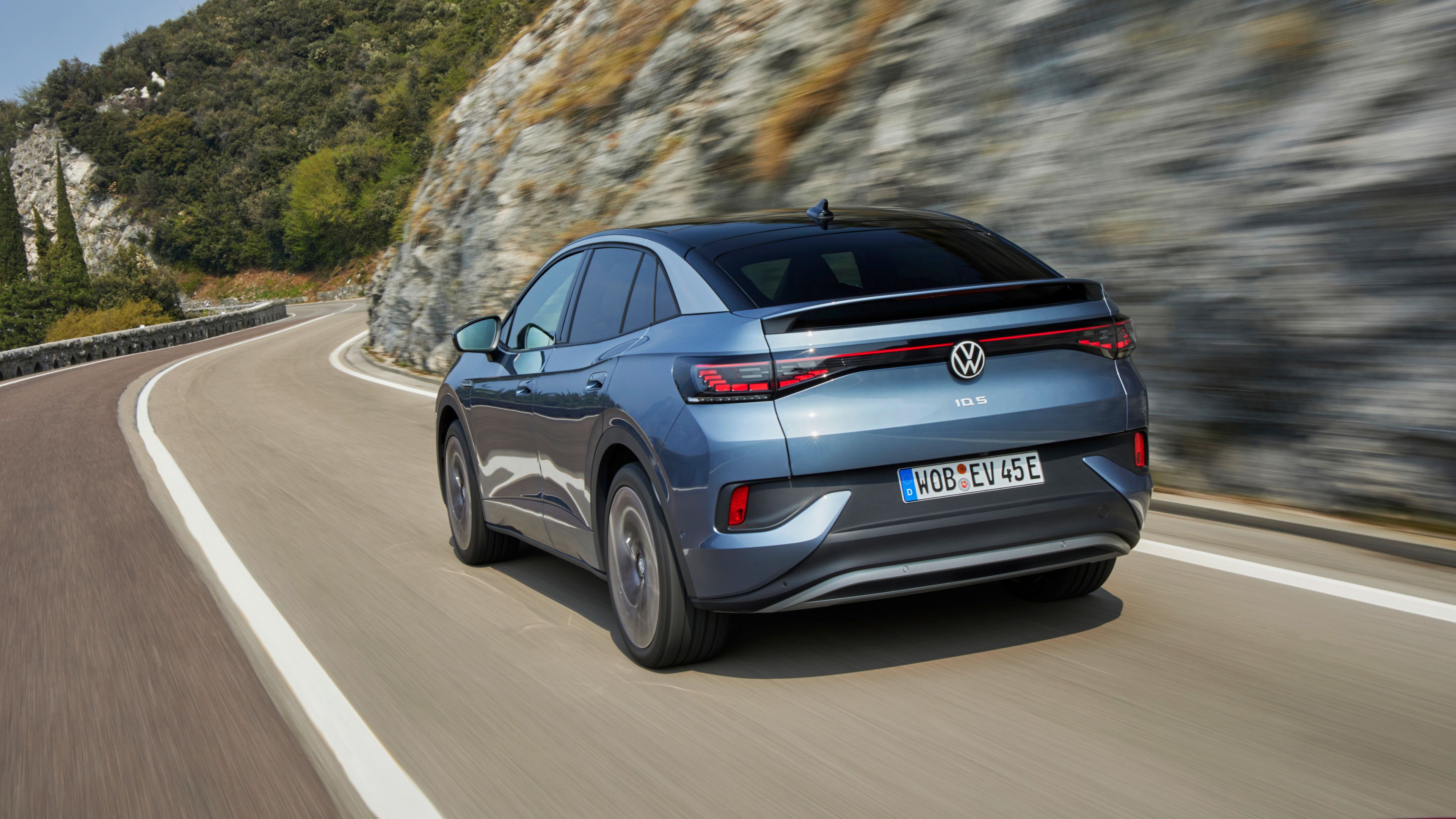 Volkswagen ID.4 moving in a fast speed on the road beside the mountain