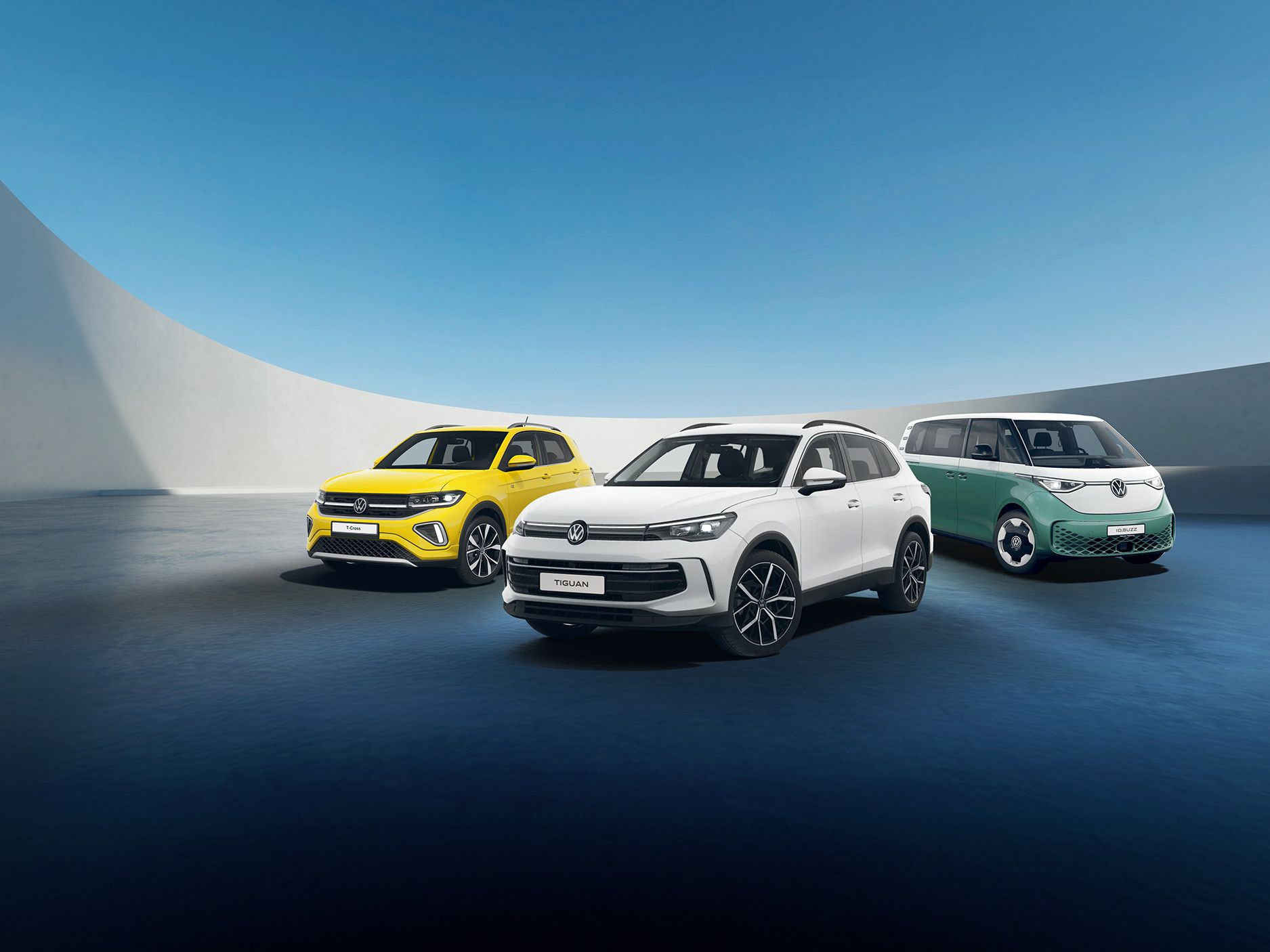A white Tiguan, yellow T-Cross and candy white green ID. Buzz against a futuristic parking spot