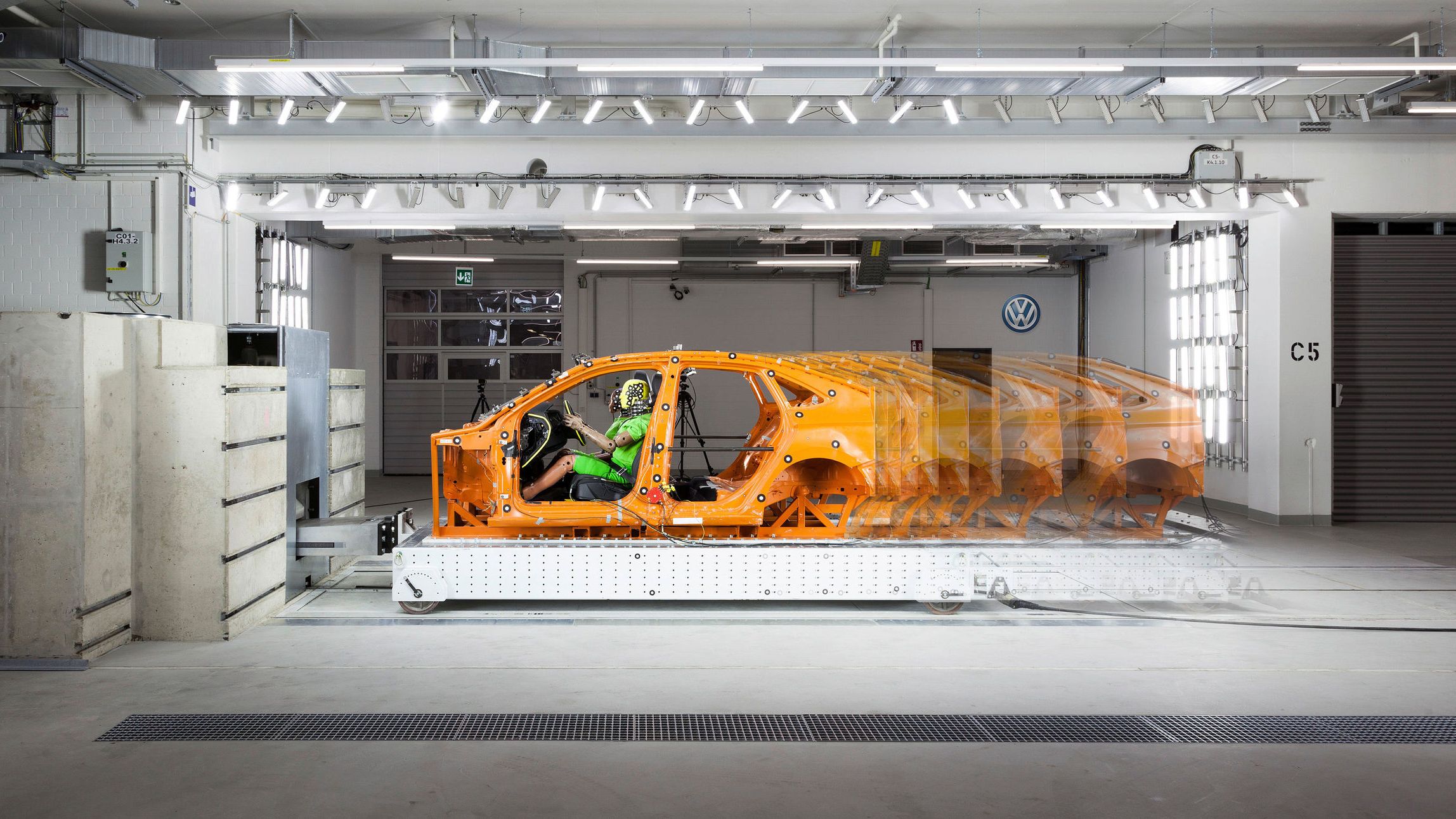 A collision experiment conducted in a Volkswagen R&D centre involving a crash dummy placed inside the frame or body of a Volkswagen vehicle.