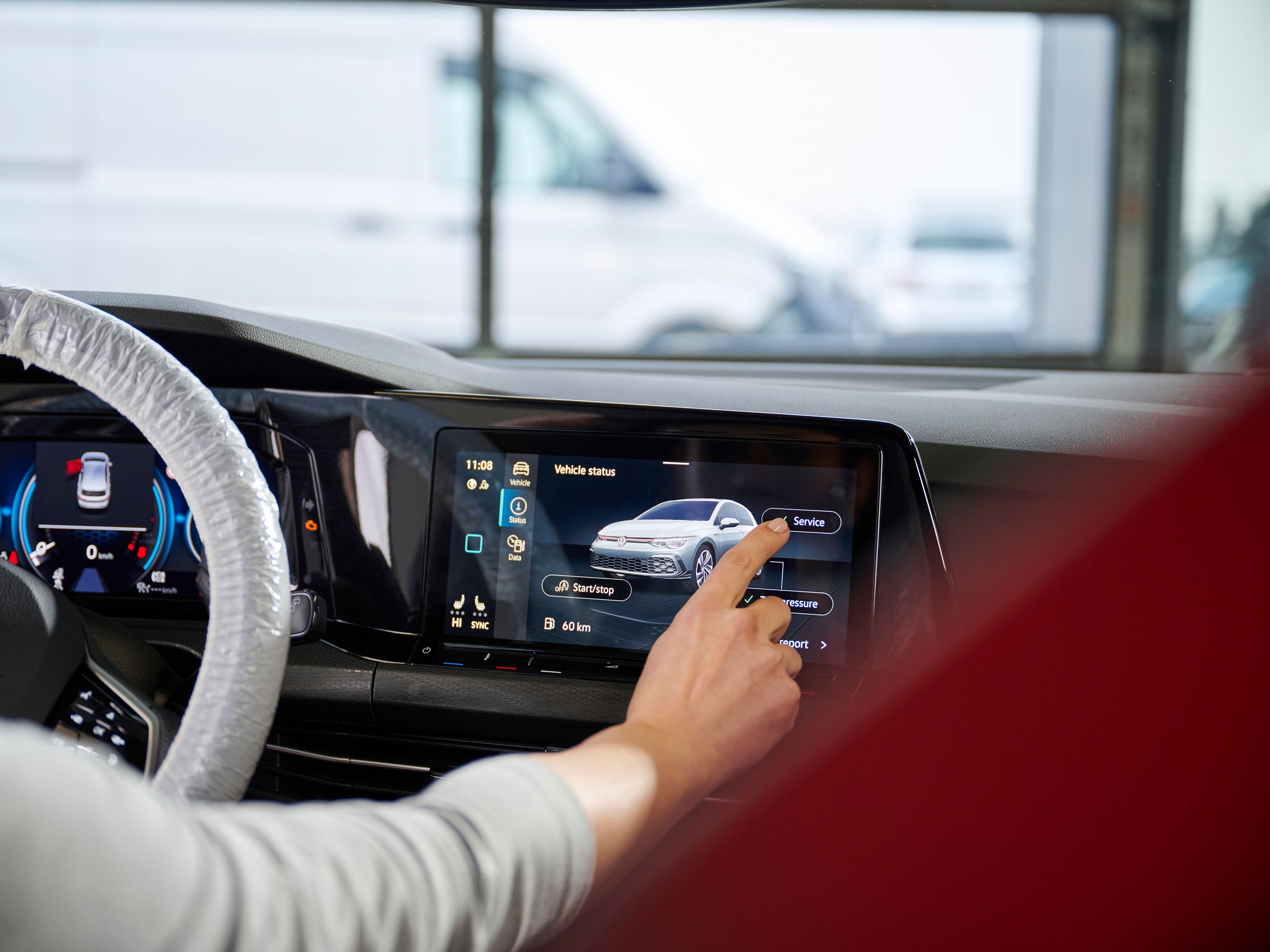 An individual is seen touching the infotainment system inside a Volkswagen vehicle.