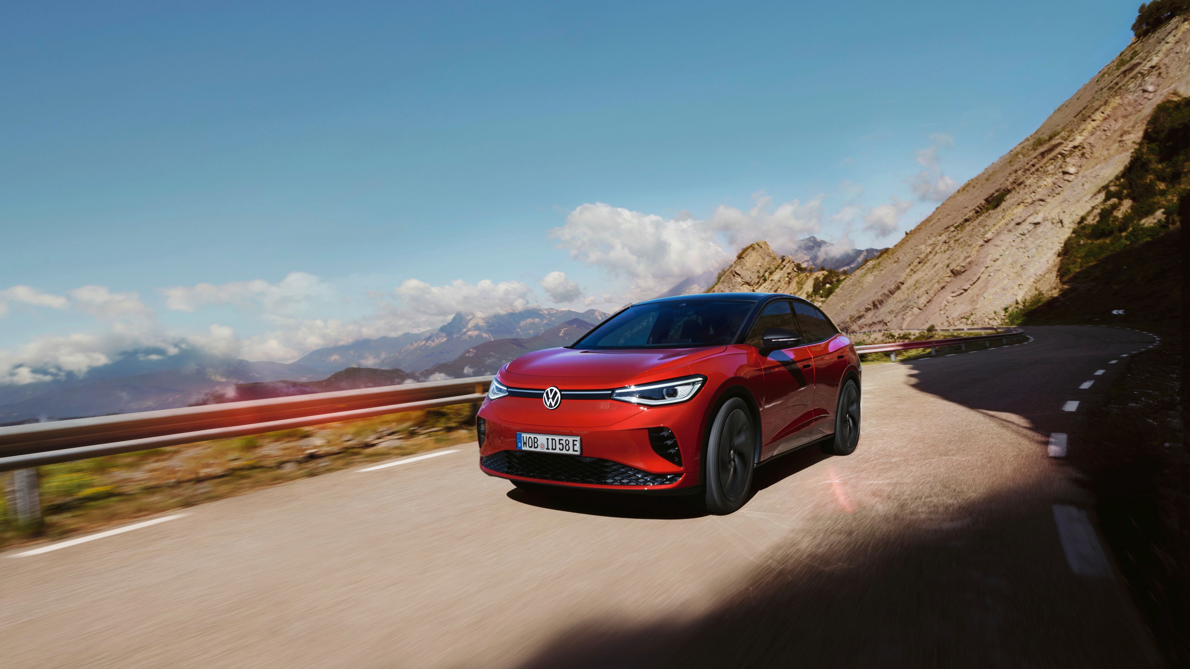 A Kings Red Premium Metallic Volkswagen ID.5 GTX is passing through a mountain 