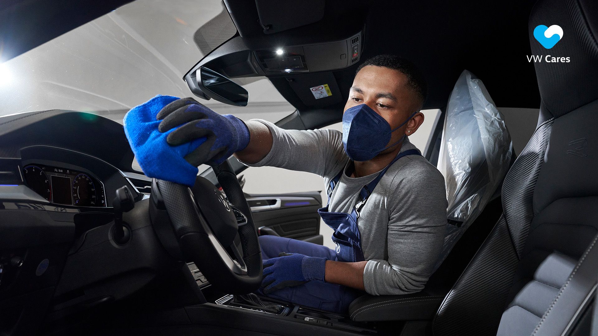 A certified Volkswagen Staff wipes down the steering wheel with precision 