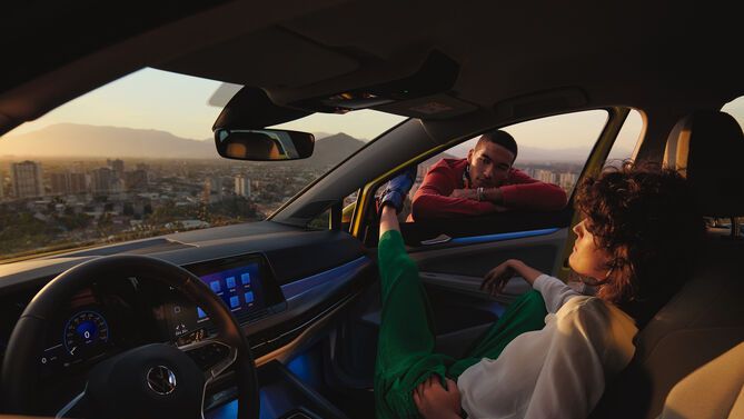 Two individuals using the Golf R's voice feature which is activated by saying "Hello Vokswagen" to enable voice commands.  