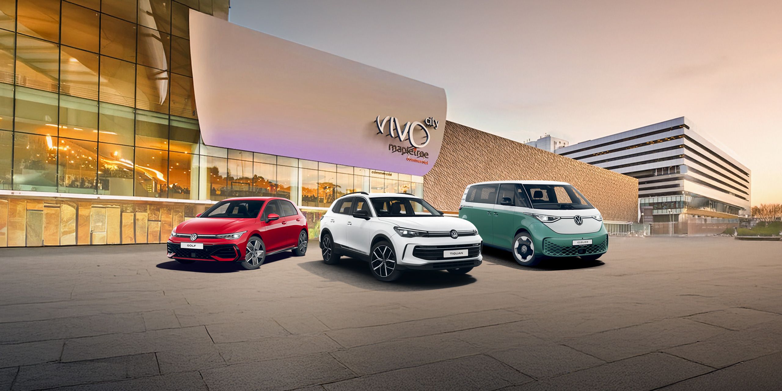 A red Golf, white Tiguan and a candy white and green ID. Buzz parked in front of the VivoCity facade