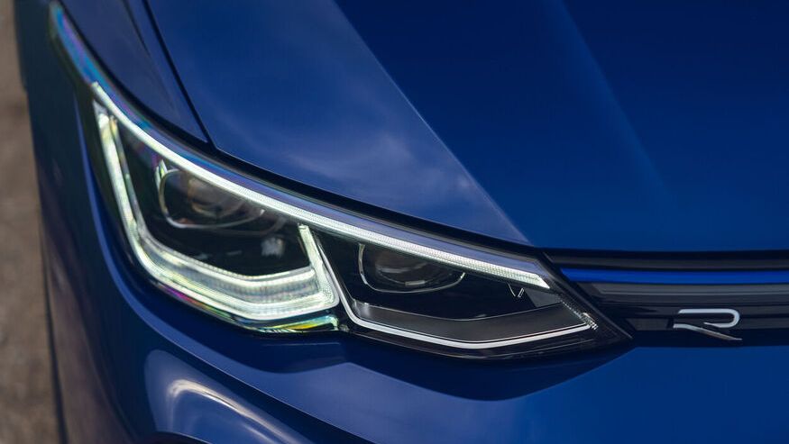 The blue Volkswagen vehicle with the 'R' badge label beside the front LED headlight