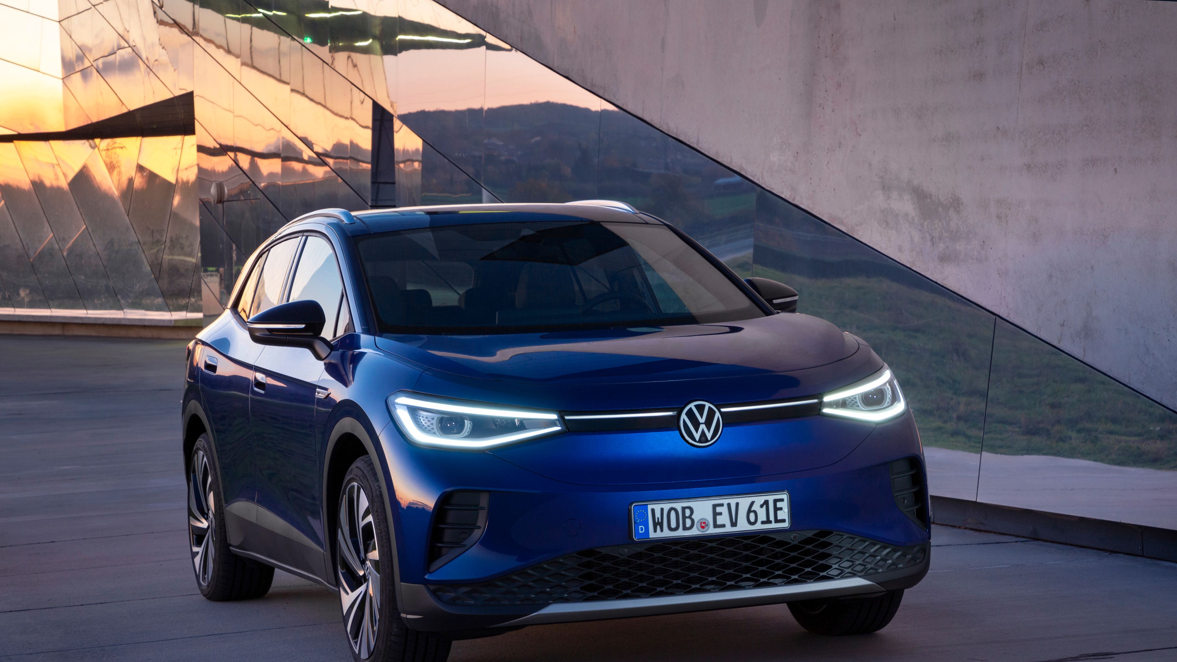 A stationary Blue Dusk Metallic Volkswagen ID.4 in a contemporary building environment.