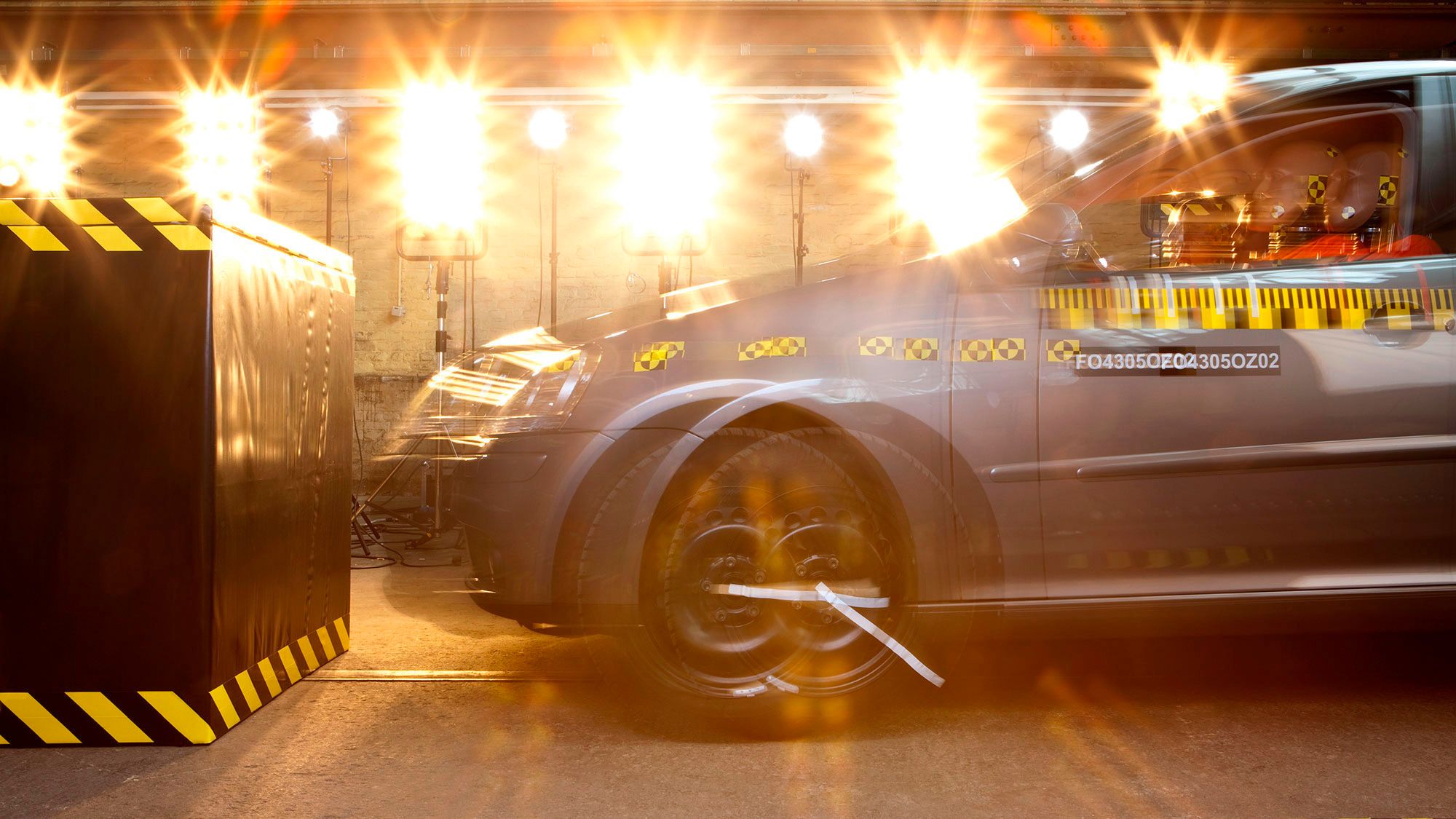 A close up look of a vehicle going through a collision test in a secured and bright environment.