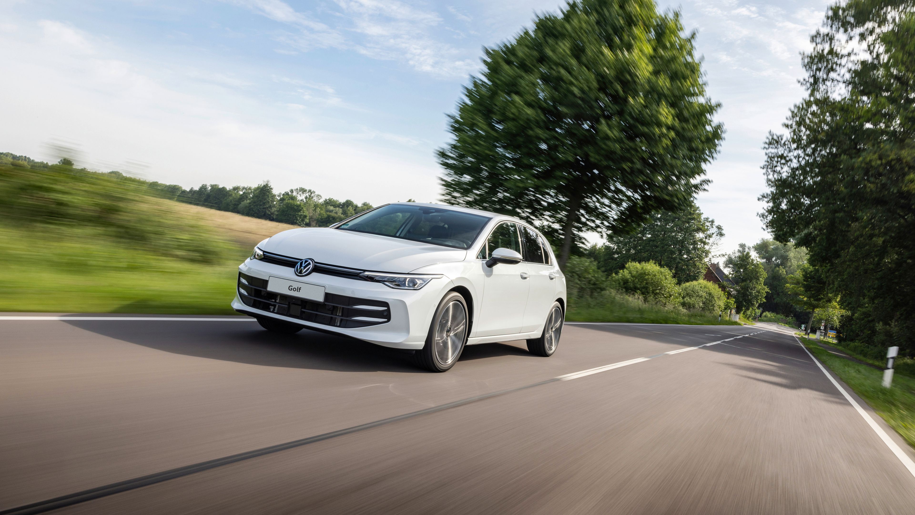 A white Golf 8.5 cruising by the countryside