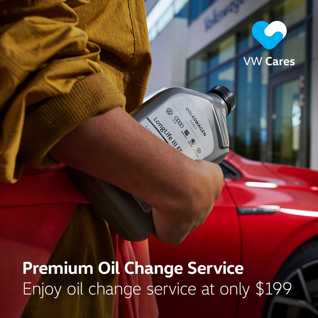 An individual holding onto a bottle of Volkswagen Premium Oil