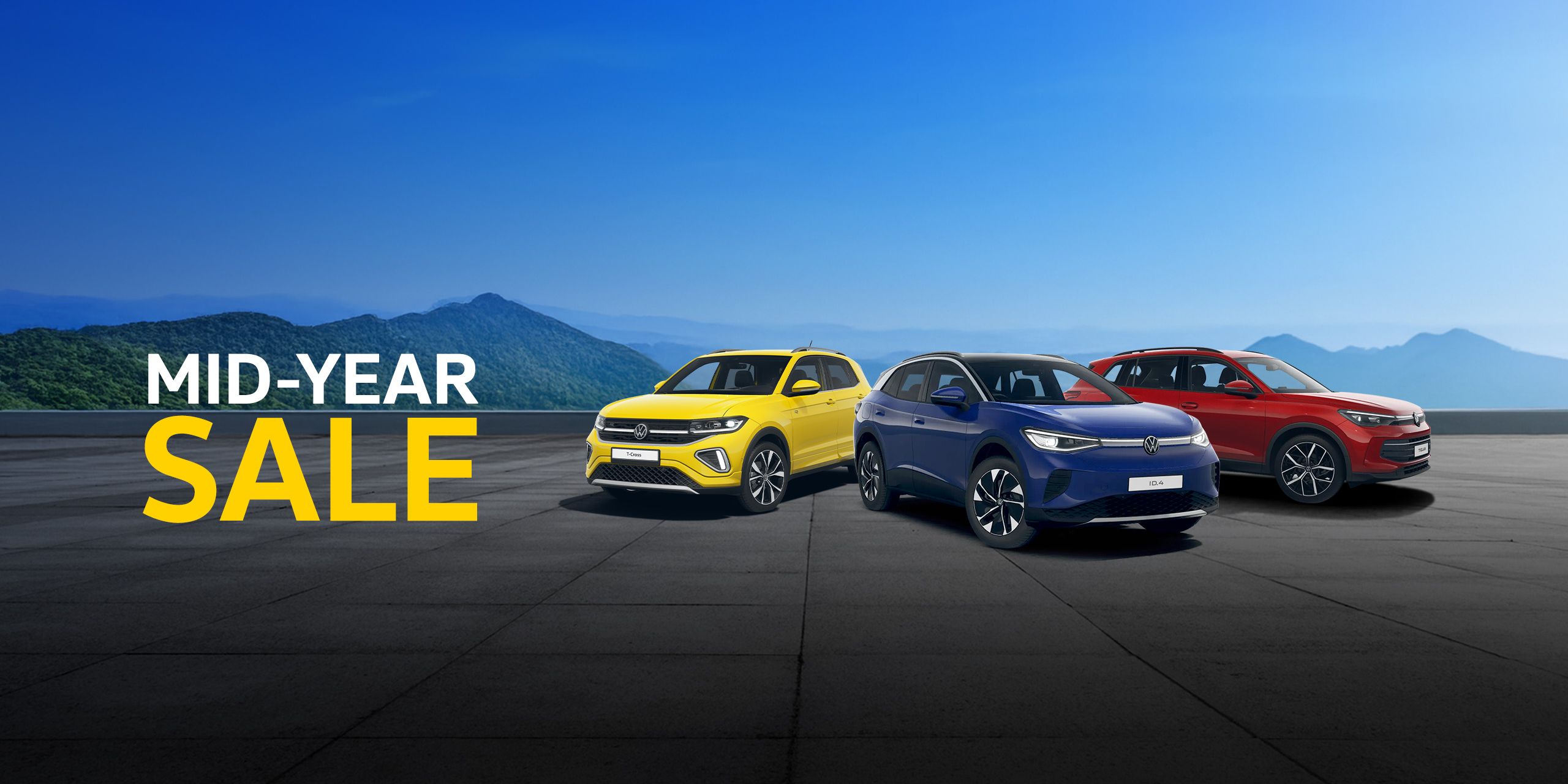 A range of Volkswagen cars showcased in front of a mountainous background