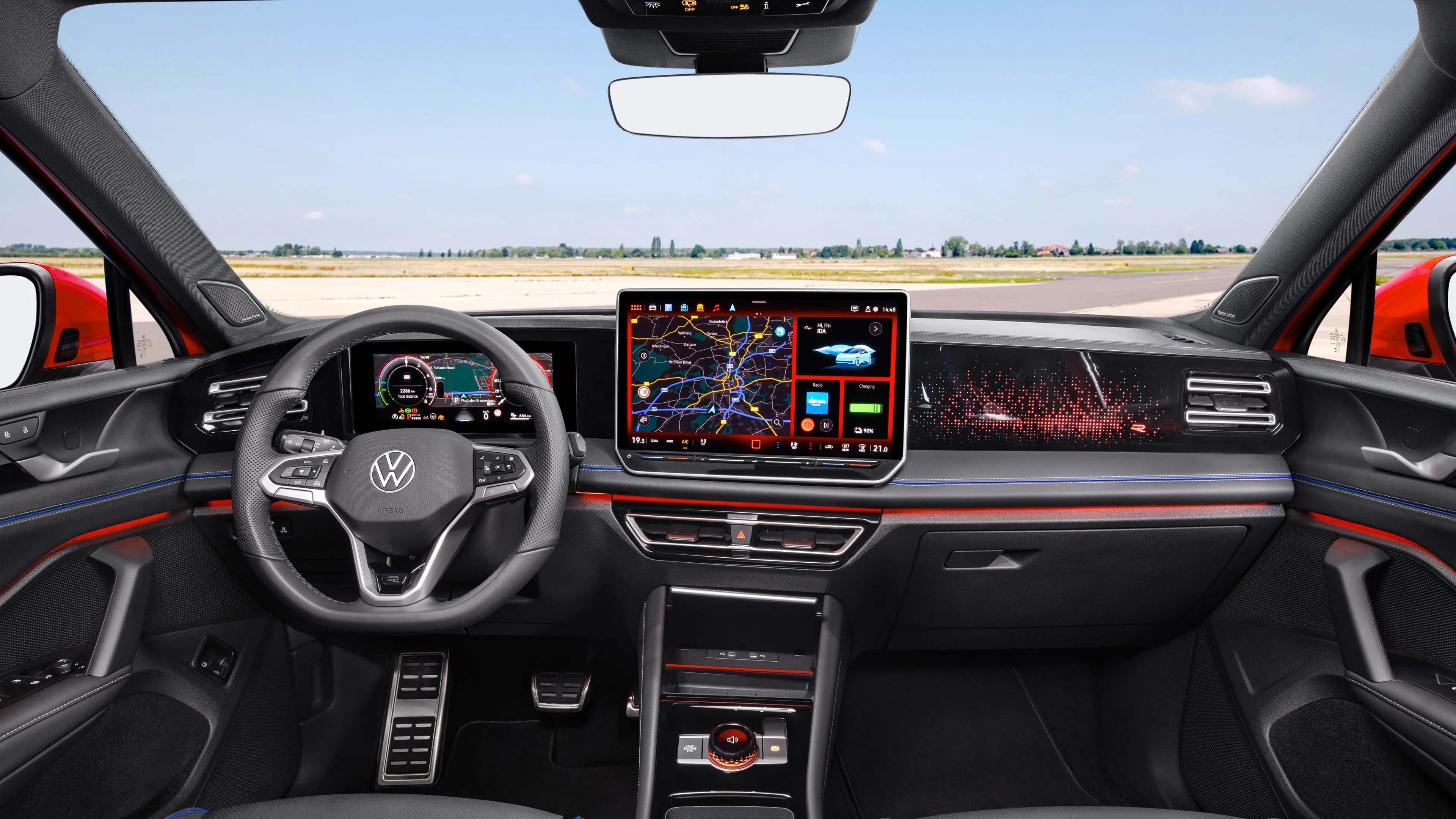 The interior of a Volkswagen Tiguan with a sporty black leather steering wheel and seats.